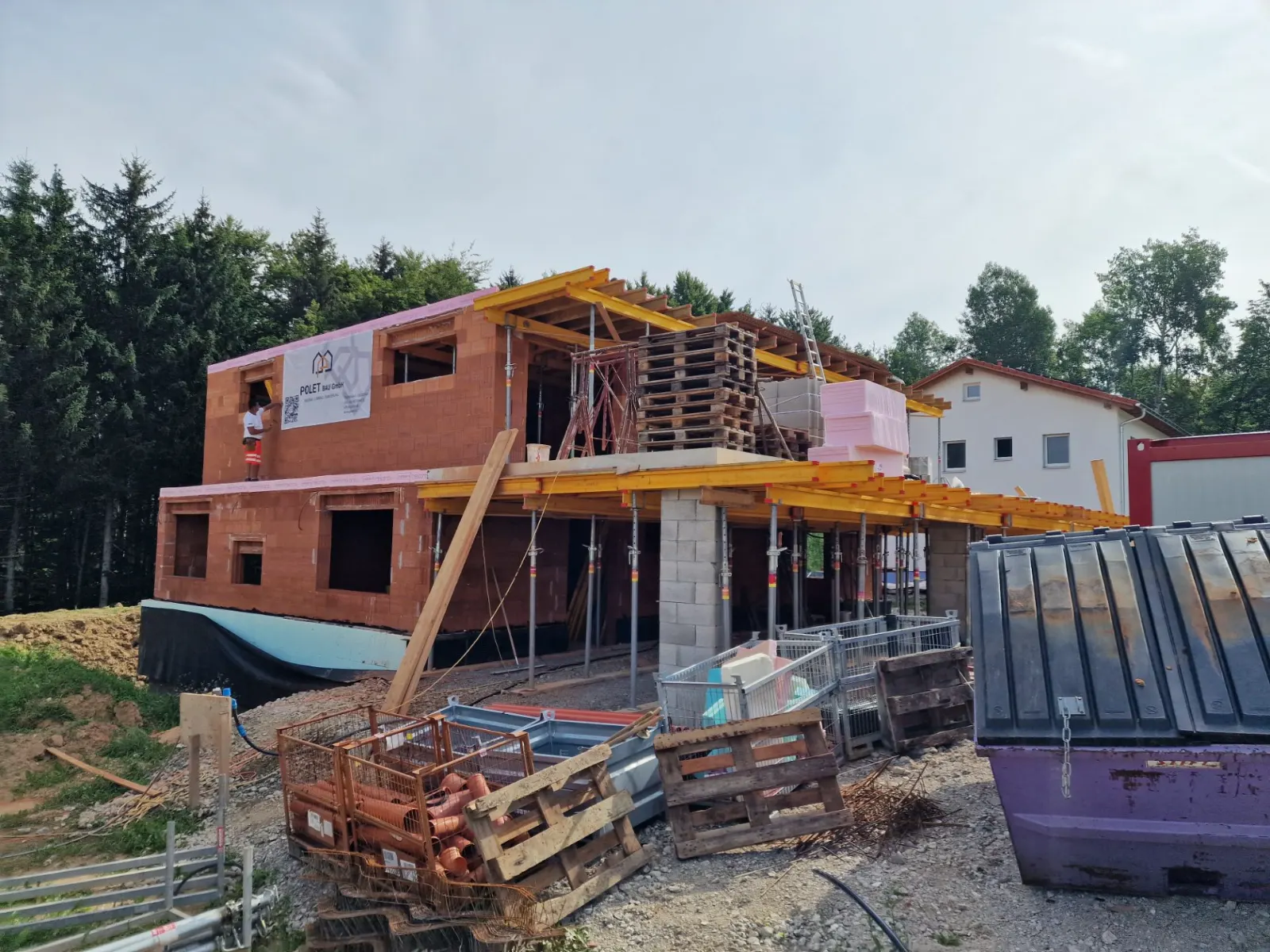 Rohbau eines Doppelhauses in Gleisdorf mit Polet-Bau-Baustellentafel und Deckenschalung